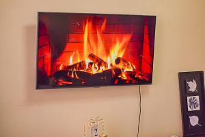a television hanging on a wall with a fireplace at EnZ lovely 2 bedroom Apartment Milimani Nakuru in Nakuru