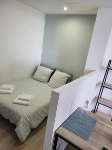 Kleines Zimmer mit einem Bett und einem Tisch in der Unterkunft Appartement place du Canada in Valenciennes