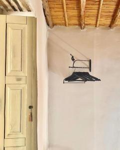 un appendiabiti nero su un muro accanto a una porta di Relais 1893 a Oliena