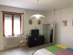 a bedroom with a bed and a tv and a chair at Alloggio Turistico Pratoterra in Bracciano