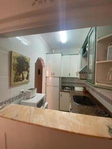 une cuisine avec des placards blancs et un comptoir dans l'établissement Nice apartment Torrecilla Beach, à Nerja