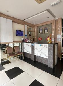 a kitchen with a counter and chairs in a room at Intanova Hotel in Teluk Intan