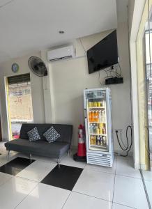 a living room with a refrigerator and a couch at Intanova Hotel in Teluk Intan