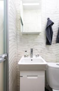 ein weißes Bad mit einem Waschbecken und einem WC in der Unterkunft Studio Maria- Prime Location in Kapana District in Plowdiw