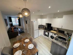 a kitchen and living room with a table and chairs at 3 Bedroom New House with Wi-Fi Sleep 5 By Home Away From Home - A in Newcastle under Lyme
