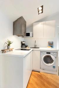 a white kitchen with a washing machine and a sink at Plaza Mayor Ático Madrid in Madrid