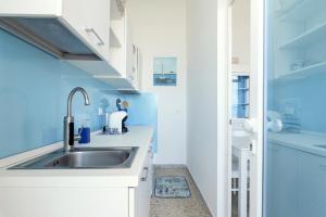 una cucina con lavandino e pareti blu di Casa Helios a Villanova