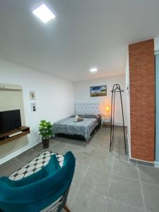 ein Wohnzimmer mit einem Bett und einem TV in der Unterkunft Suite Vargem Grande 2 - praia, cachoeira e trilhas in Rio de Janeiro
