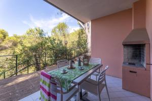 patio ze stołem i krzesłami na balkonie w obiekcie Camping Village Rosselba Le Palme w mieście Portoferraio