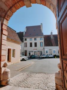 Blick auf eine Straße durch einen Torbogen in der Unterkunft Les Petites Forges in Auxonne