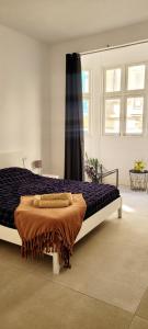 una camera da letto con un grande letto con una coperta marrone di Green door Valletta a La Valletta