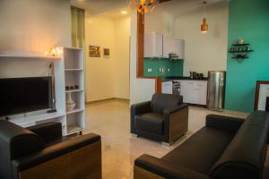 a living room with a couch and chairs and a kitchen at Natamber apartment in Rubavu