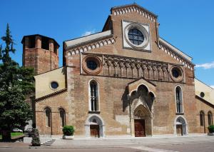 un grand bâtiment en briques avec une tour d'horloge dans l'établissement AVD - La Nuova Casa di Nonna, à Udine