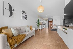 sala de estar con sofá y cocina en HOLYHOME SunSplash, en Costa Teguise