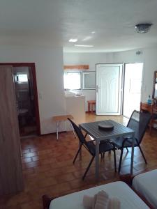 a living room with a table and chairs and a kitchen at Samos Rooms in Pythagoreio