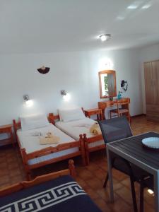 a bedroom with two beds and a table and a table and chairs at Samos Rooms in Pythagoreio