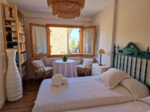 a bedroom with a bed and a table and a window at ESQUÍ PIRINEO ARAGONÉS APARTAMENTO EL JUNCARAL Wifi in Villanúa