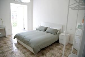 a white bedroom with a bed and a window at Casa di Nonna Maria in Caserta