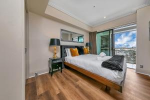 a bedroom with a large bed and a window at Sunset Serenade in Auckland