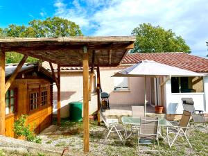 un patio con mesa y sombrilla en Gîte ylangylang en Saint-Paul-le-Jeune