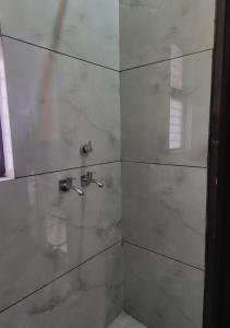 baño con ducha y puerta de cristal en Panipat Town House panipath en Pānīpat