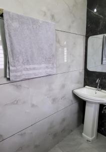 a white bathroom with a sink and a mirror at Panipat Town House panipath in Pānīpat