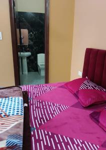 1 dormitorio con 1 cama con sábanas moradas y espejo en Panipat Town House panipath en Pānīpat