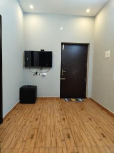 Habitación con puerta negra y suelo de madera. en JK Resort en Yercaud