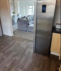 a kitchen with a stainless steel refrigerator and a couch at SEA VIEW Apartment Large Balcony Whirlpool Bath 2 Bedrooms SKY GLASS TV in Bridlington