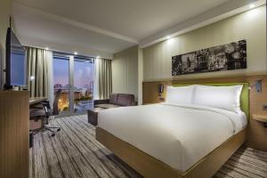 a hotel room with a large bed and a desk at Hampton by Hilton Istanbul Atakoy in Istanbul