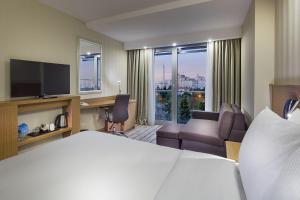 ein Hotelzimmer mit einem Bett und einem Wohnzimmer in der Unterkunft Hampton by Hilton Istanbul Atakoy in Istanbul