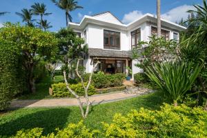 a white house with trees and bushes at Lotus Samui Luxury Beach Villas in Mae Nam
