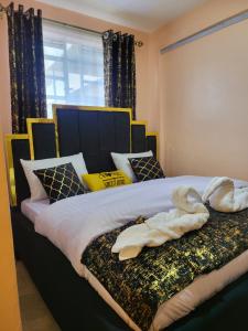 a bedroom with a large bed with towels on it at G&G Executive Homes Pipeline Nakuru in Nakuru