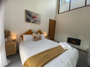 een slaapkamer met een groot bed met witte lakens bij Riverlin Estate in Warburton