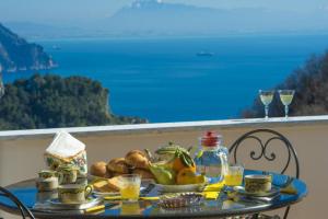 einen Tisch mit einem Teller Essen auf dem Balkon in der Unterkunft Casa Mary in Amalfi