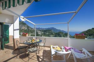 eine Terrasse mit Tisch und Stühlen auf einem Balkon in der Unterkunft Casa Mary in Amalfi