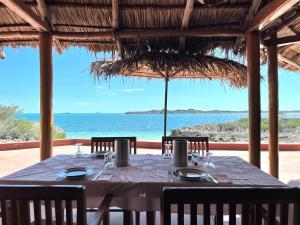 a table in a restaurant with a view of the ocean at Manga Lodge in Andavadoaka