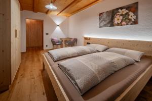 a large bed in a room with a table at Veraltenhof Agriturismo B&B in Tires