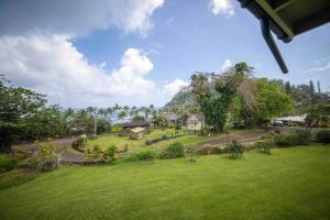 a view of a park with trees and a house at Helehele Hale in Hana