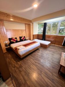 1 dormitorio con 2 camas y ventana grande en GS COTTAGE ON MALL ROAD en Shimla