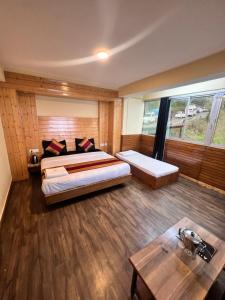 ein Hotelzimmer mit 2 Betten und einem Tisch in der Unterkunft GS COTTAGE ON MALL ROAD in Shimla