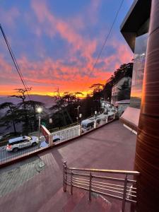 a view of a sunset from a building with a bench at GS COTTAGE ON MALL ROAD in Shimla