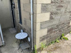 a table and a chair next to a building at The Old Post Office Double Room (town centre) in Carnoustie