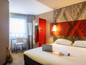 a hotel room with a bed with a laptop on it at ibis Gent Centrum Opera in Ghent