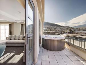a balcony with a hot tub and a couch at Sofitel Queenstown Hotel & Spa in Queenstown