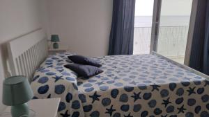 - une chambre avec un lit et une couette bleue et blanche dans l'établissement Casa Amisano, à Laigueglia