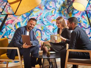 a group of people sitting around a table in a room at Novotel Paris Rueil Malmaison in Rueil-Malmaison