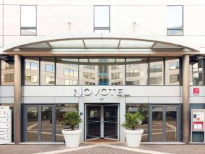 un bâtiment de nouititz avec deux plantes en pot devant lui dans l'établissement Novotel Paris Rueil Malmaison, à Rueil-Malmaison