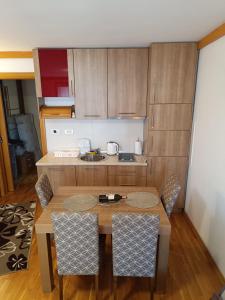 a small kitchen with a wooden table and chairs at Snježna Vila in Jahorina