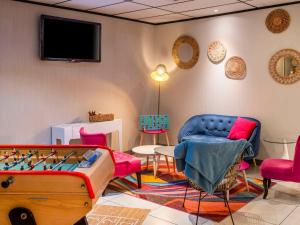 ibis Styles Blois Centre Gare في بلوا: غرفة معيشة مع طاولة وكراسي بلياردو